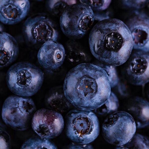 Fruits découpés sur une planche en bois avec un fond neutre